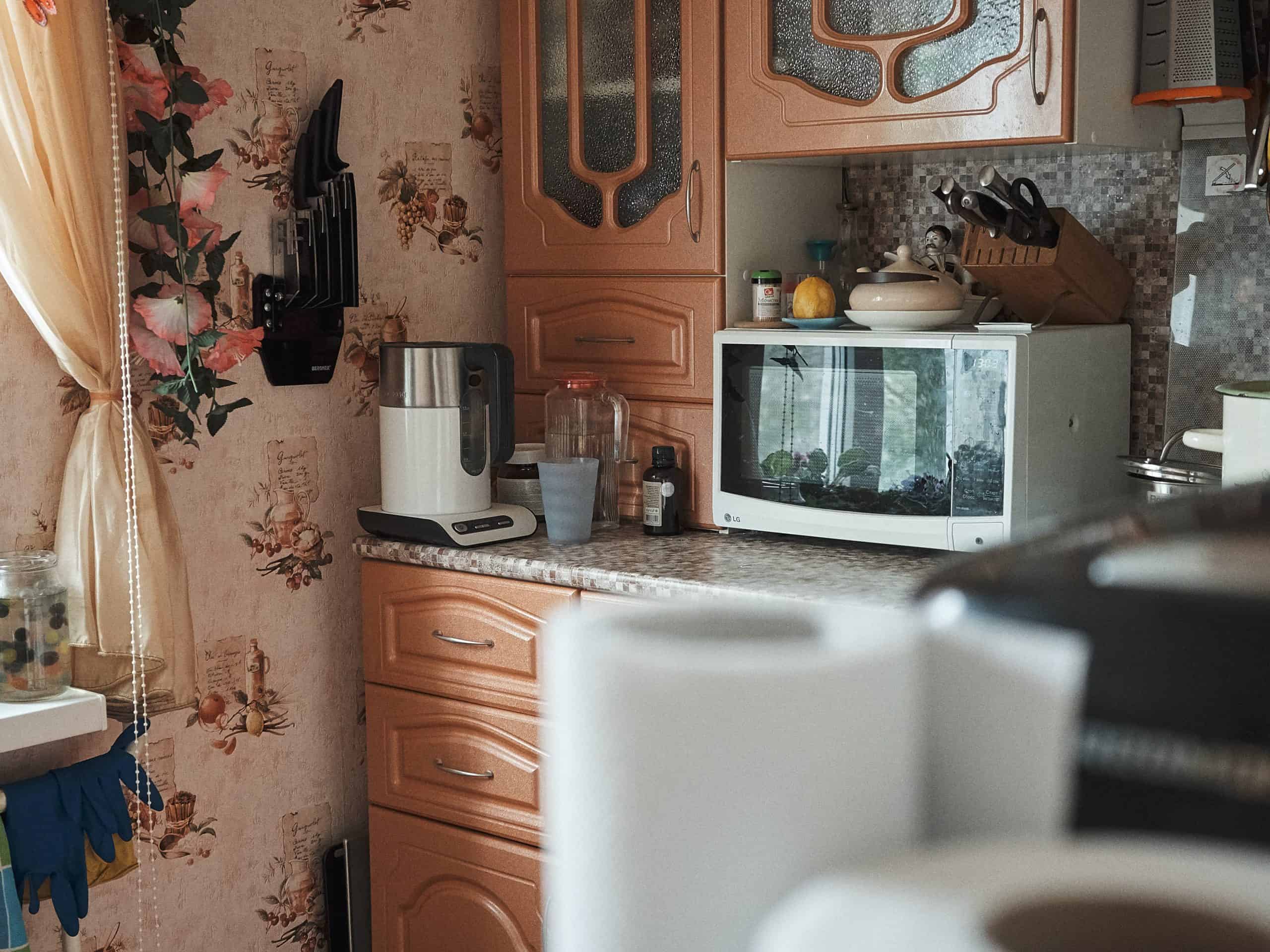 Basic microwave in a cluttered kitchen.