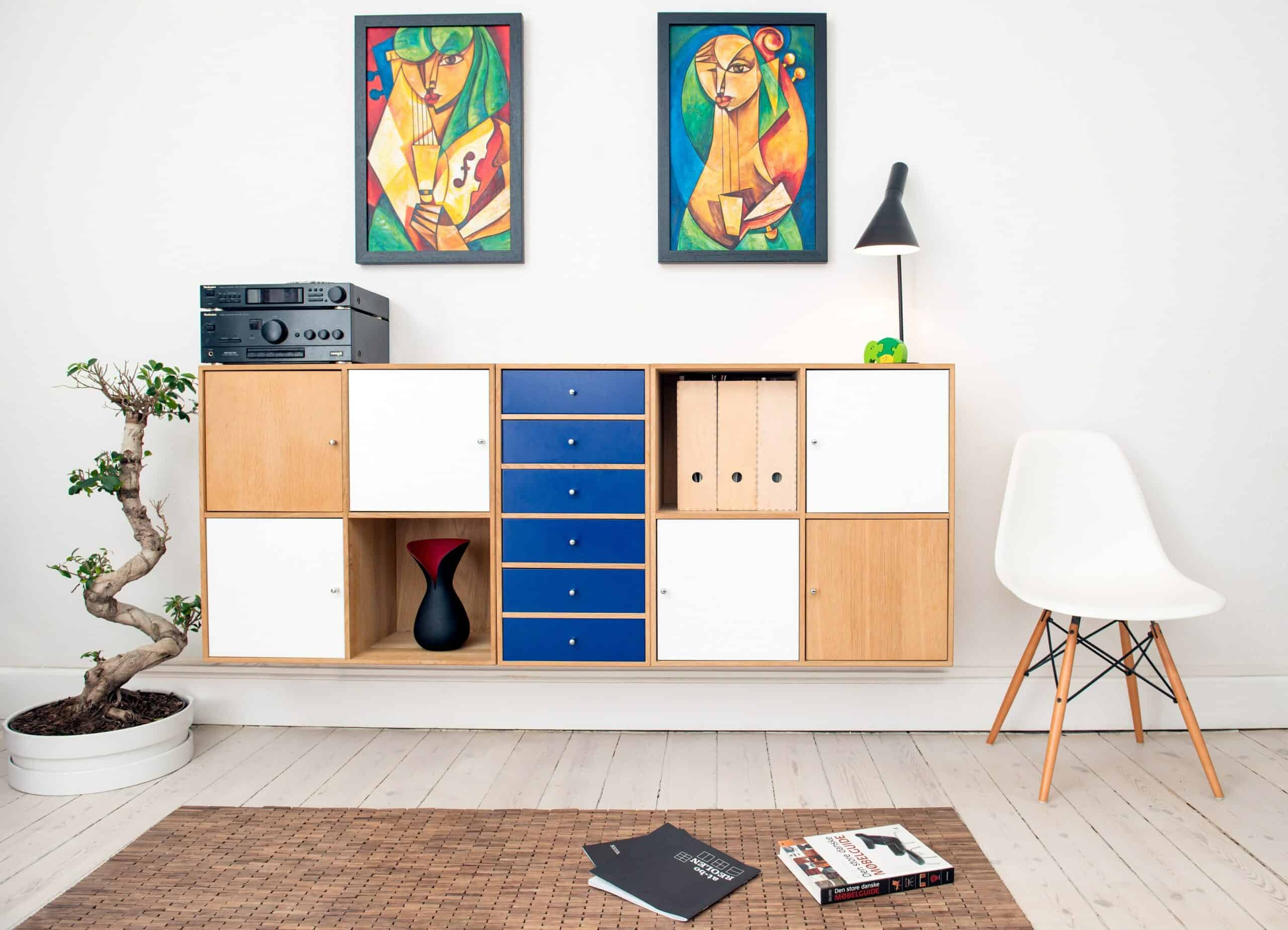 Wall with floating modern bookshelf and Cubist paintings.