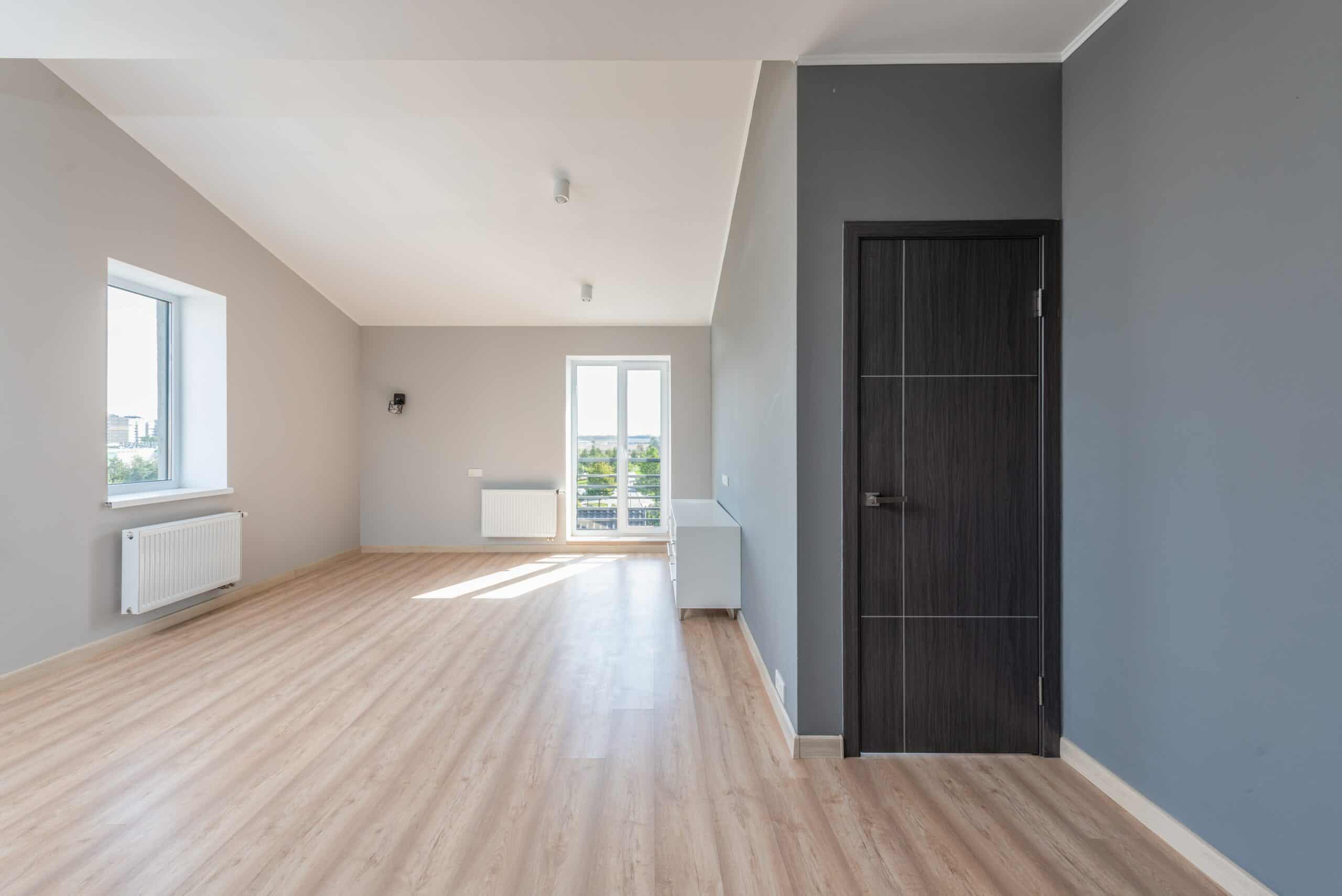 Empty room with engineered hardwood floors.