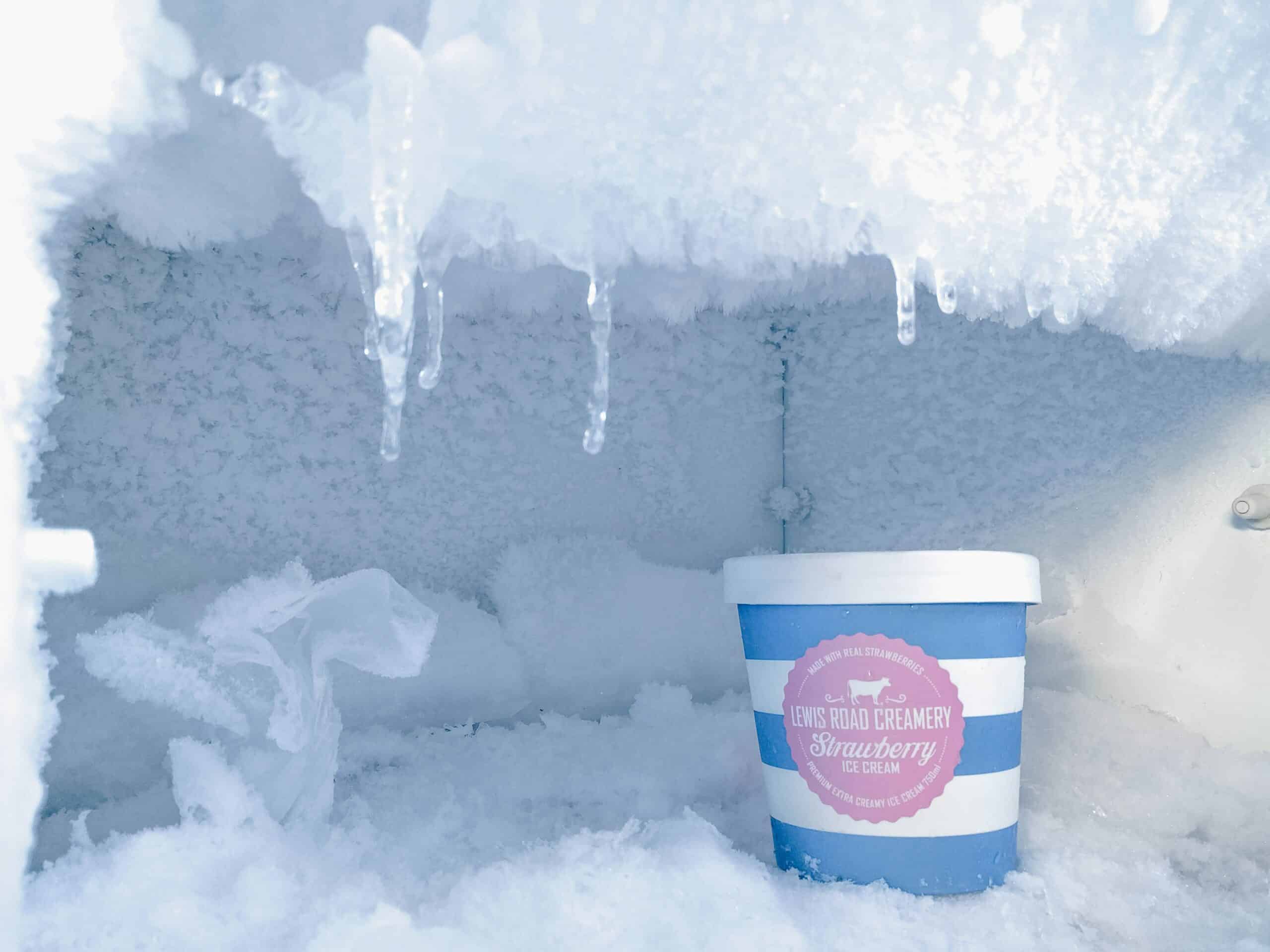 Ice cream in frosted over freezer.