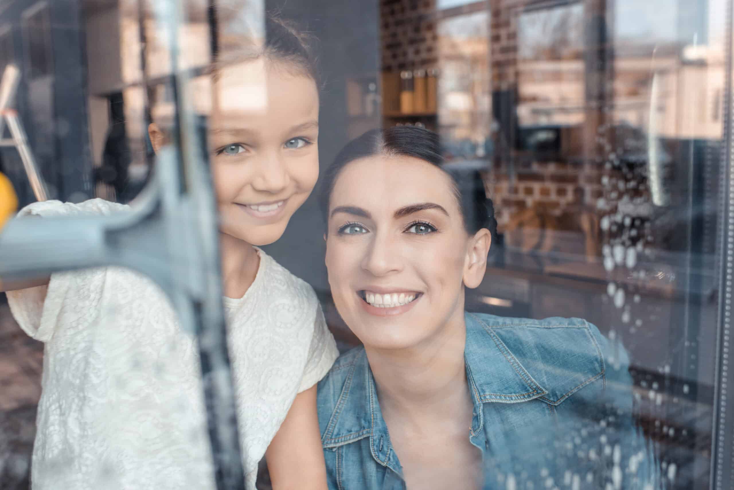 Mother and daughter cleaning window.