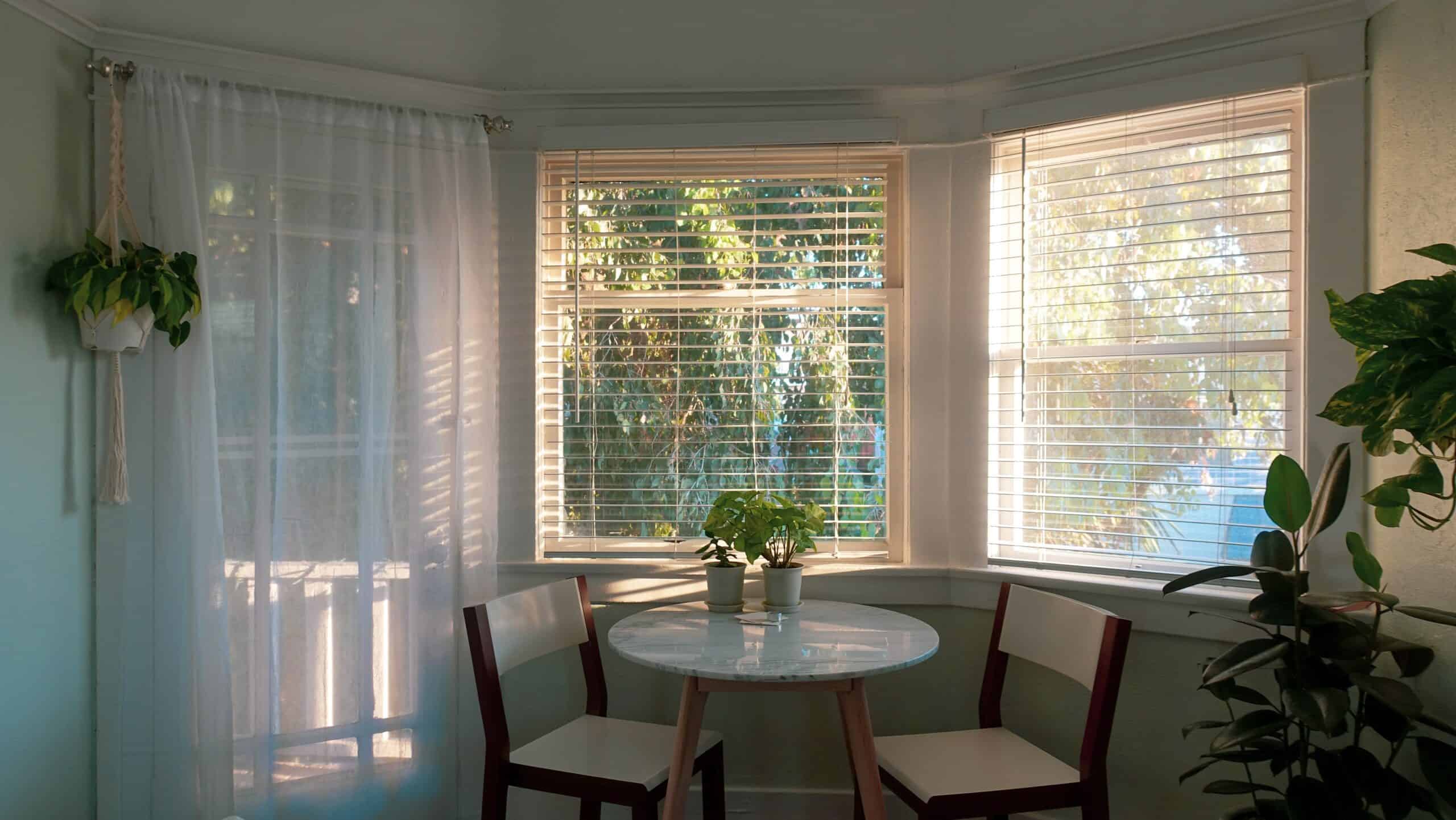 Room with three windows, a table, and two chairs.