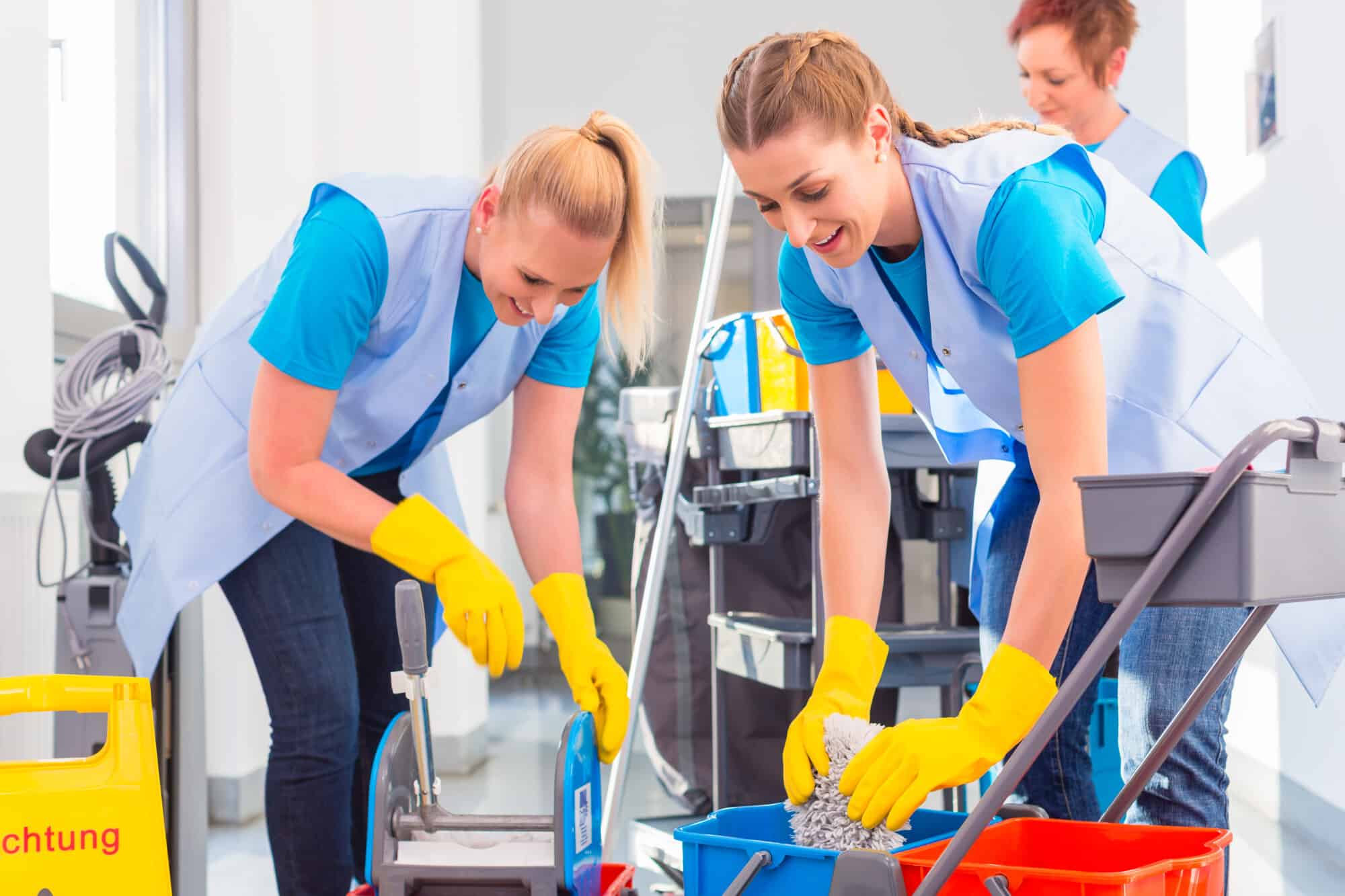 Three female professional cleaners working together.