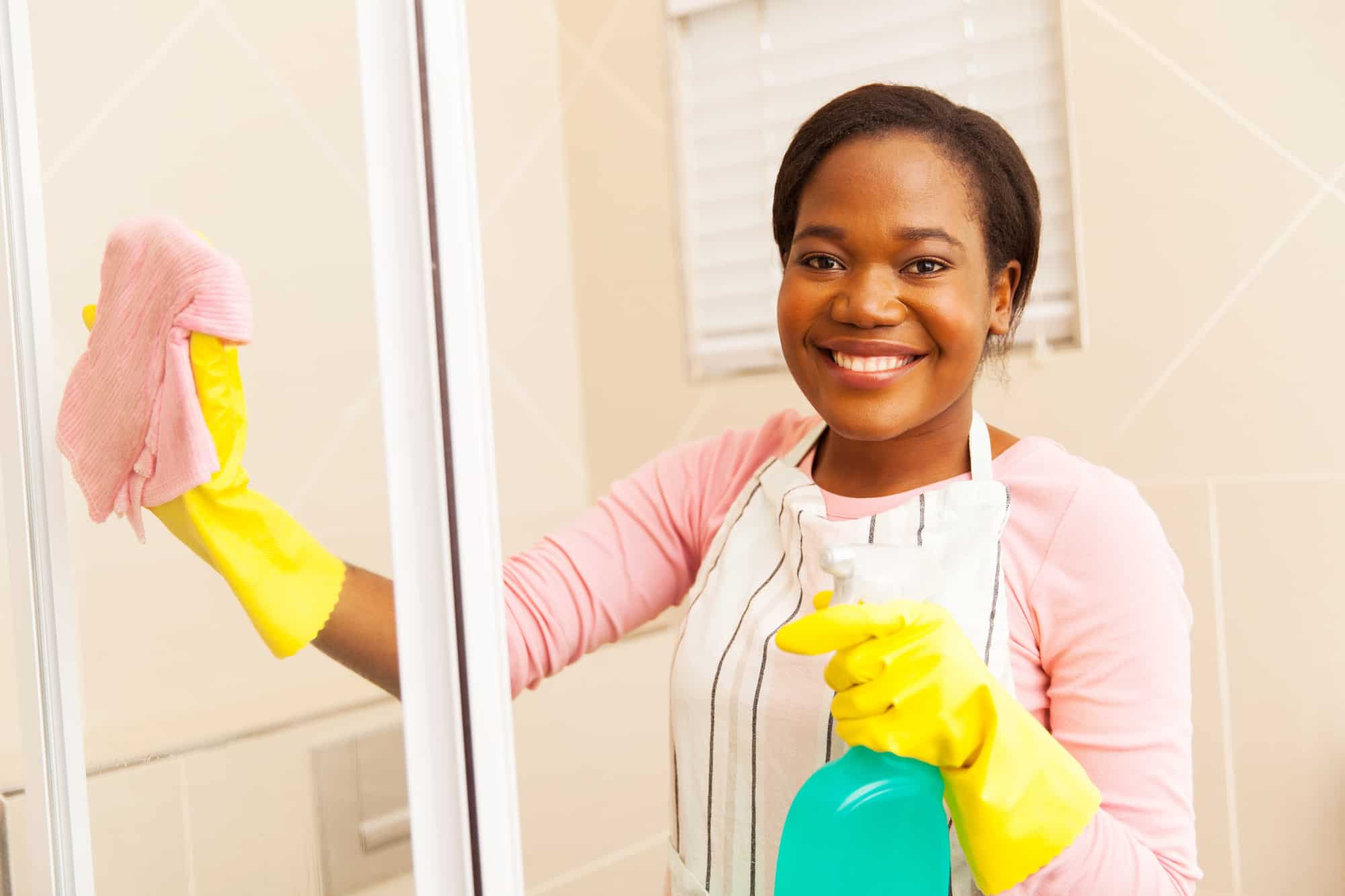 Woman cleaning shower door.