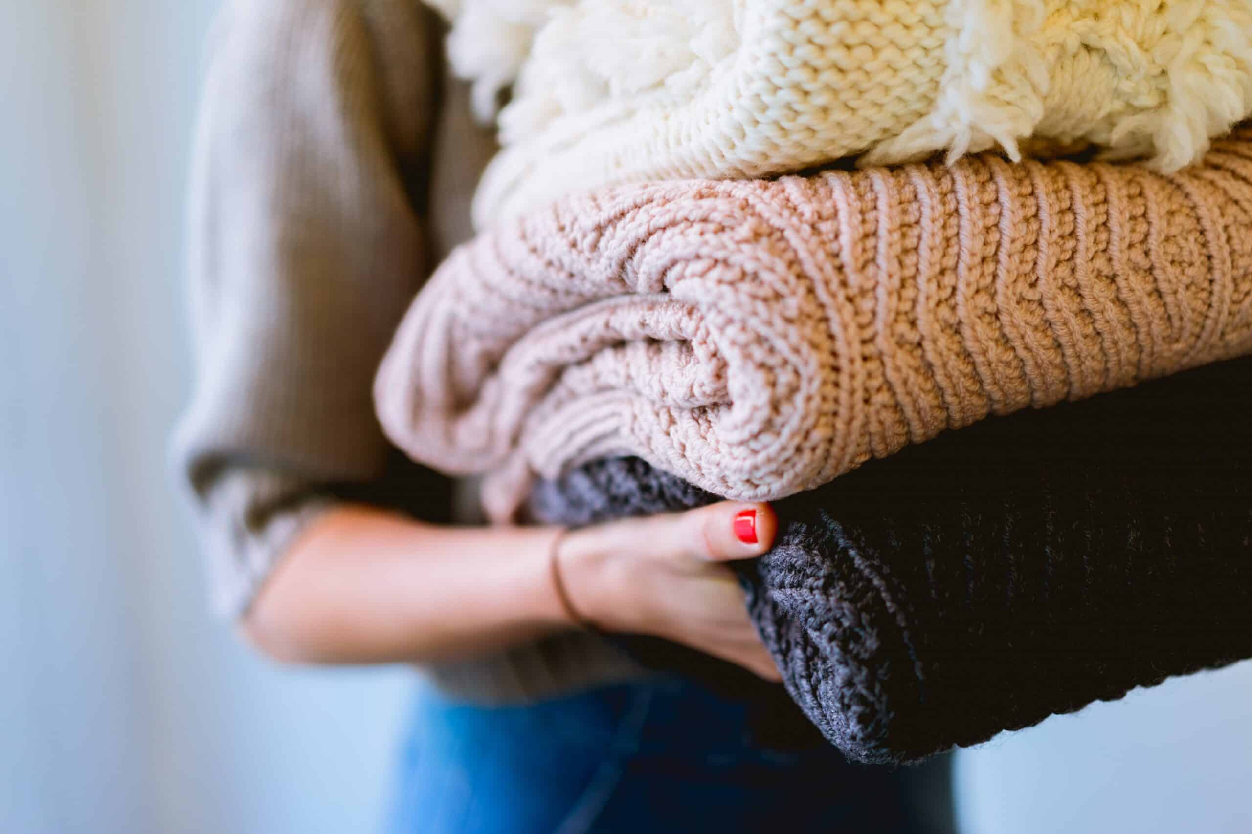 Woman holding folded clothes.