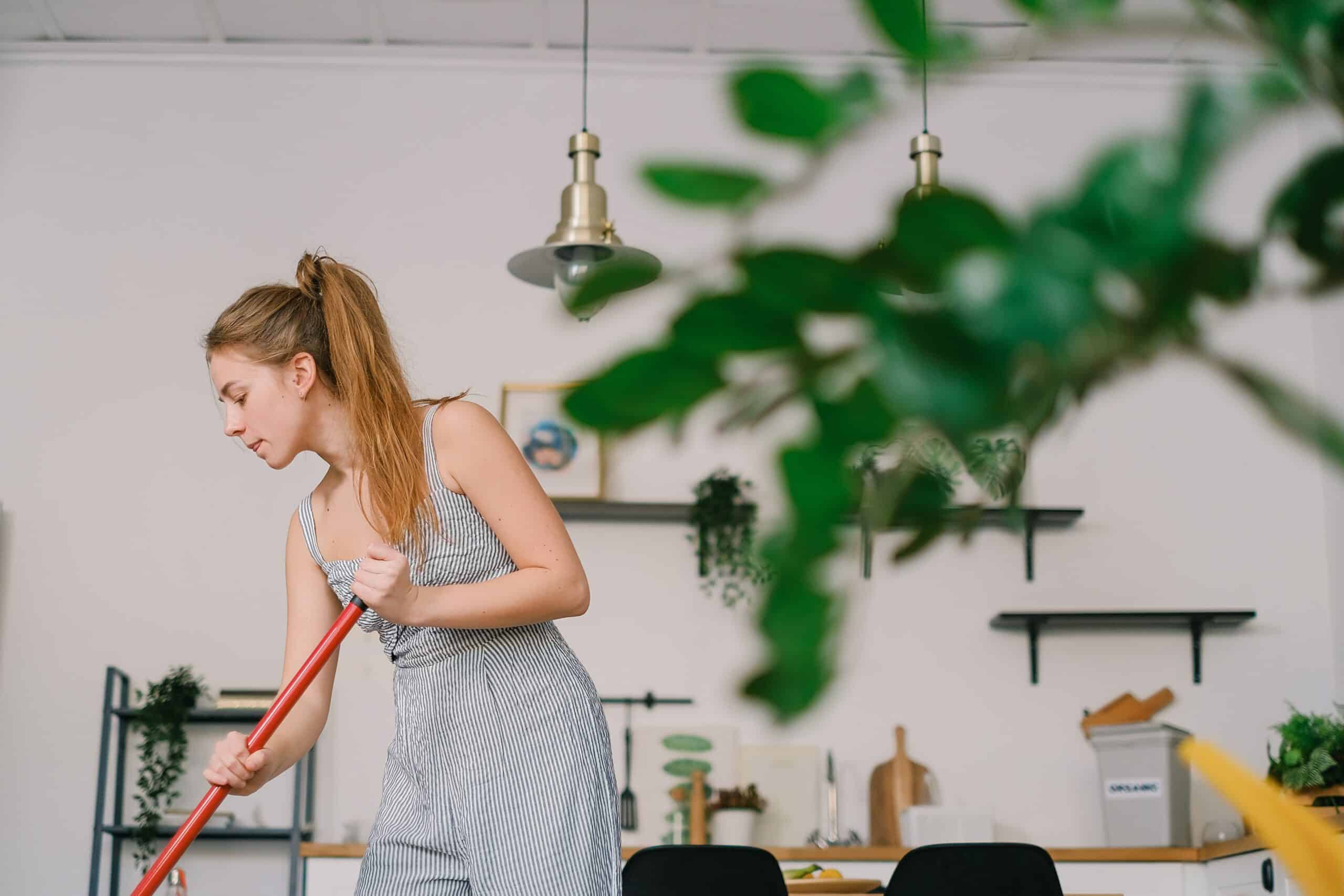 Woman mopping kitchen floor.