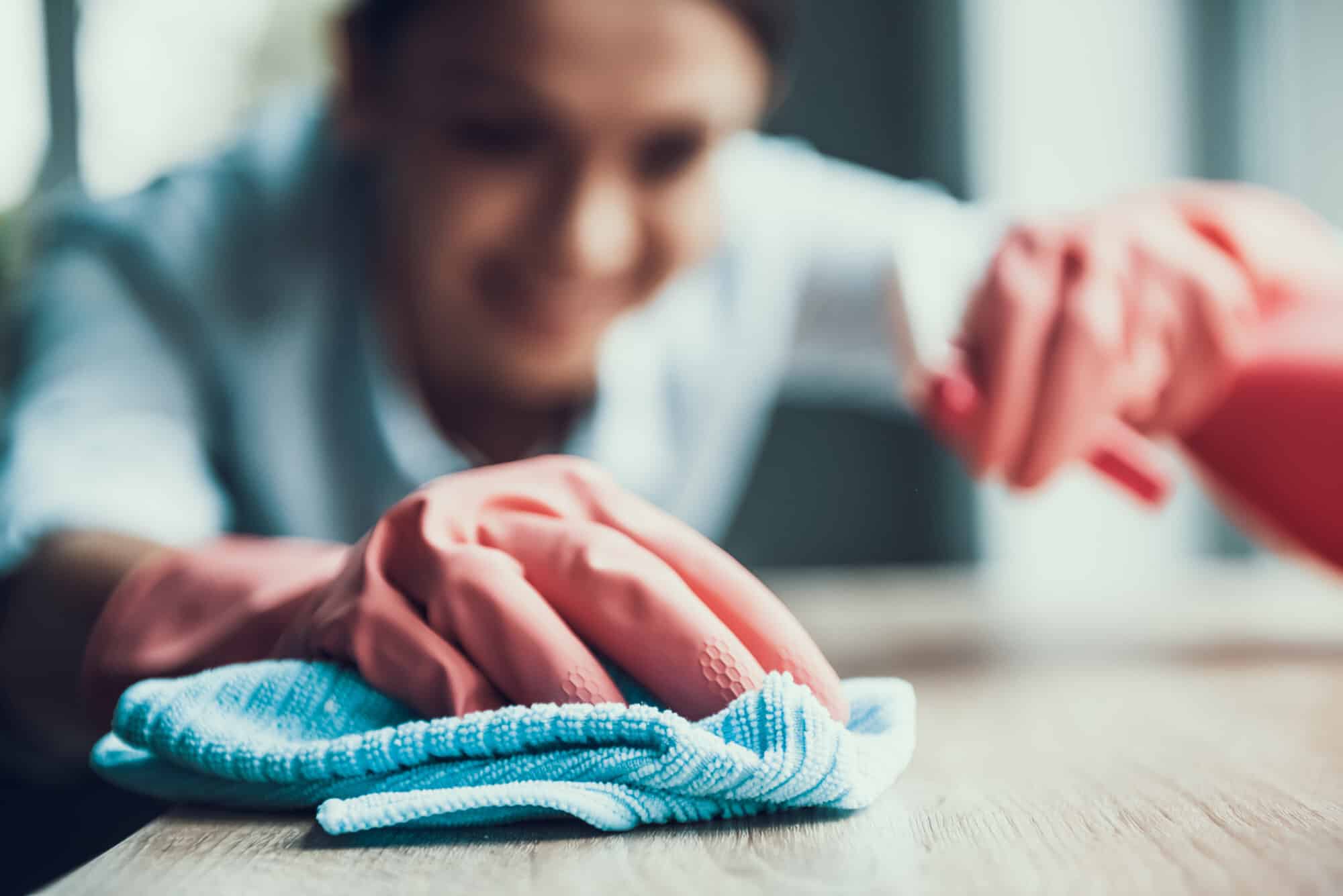 Woman spraying and wiping surface.