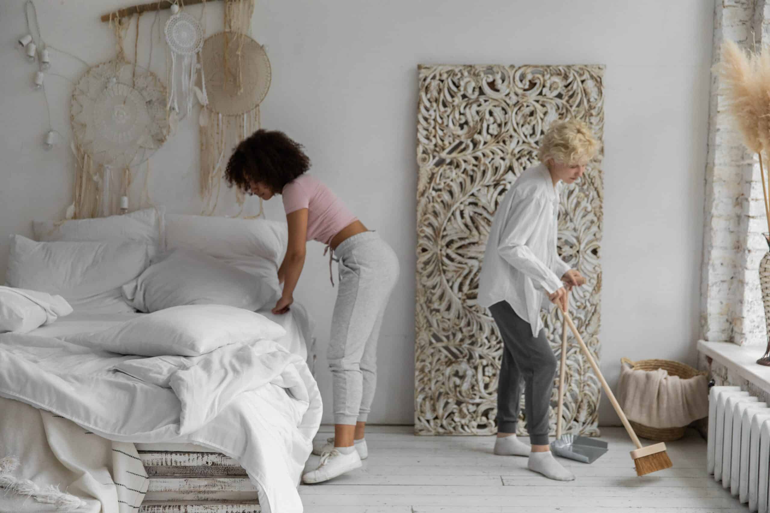 Women cleaning a bedroom.